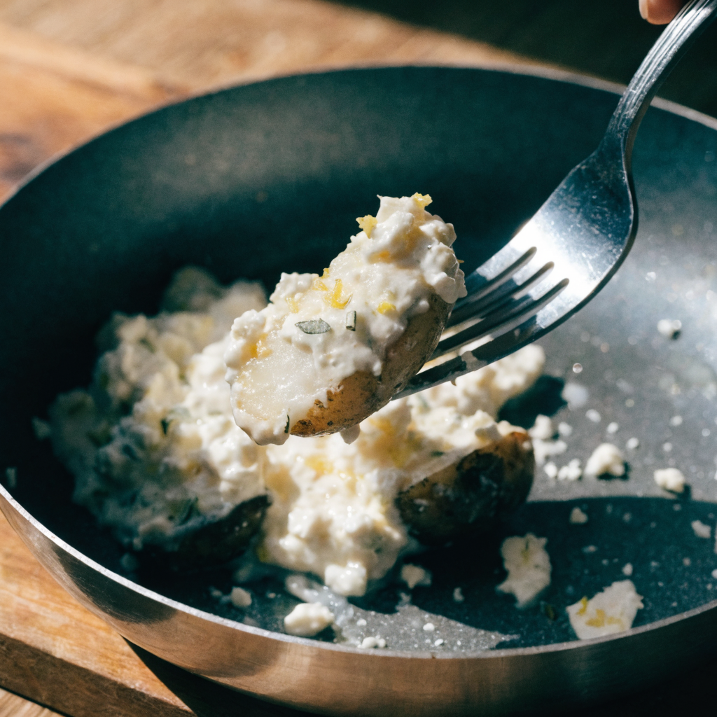Close-up of crispy baked feta roast potatoes with lemon and thyme